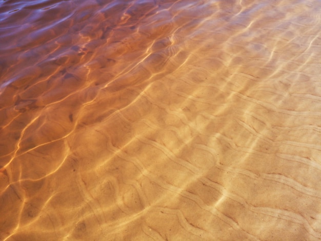 Oberfläche des goldenen Flusswassers Wasserstruktur transparentes goldenes Wasser