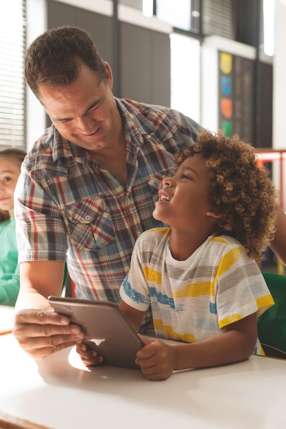 Oberflächenansicht eines Lehrers, der über ein digitales Tablet mit einem Schuljungen interagiert