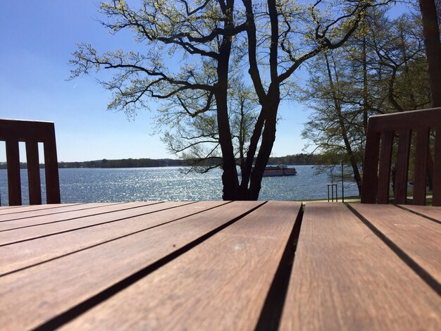 Foto oberflächenhöhe des holztisches nach baum gegenüber dem fluss an einem sonnigen tag