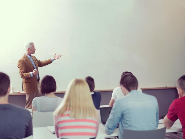 Foto oberlehrer mit einer gruppe glücklicher schüler im klassenzimmer der modernen schule