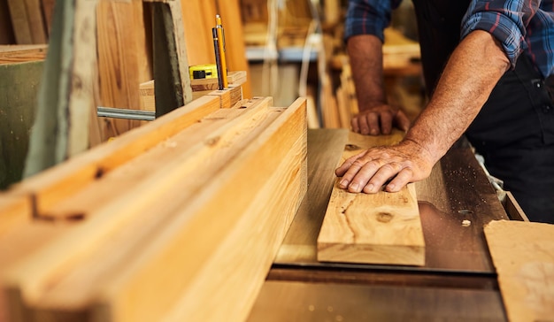 Oberschreiner in Uniform arbeitet an einer Holzbearbeitungsmaschine in der Tischlerei