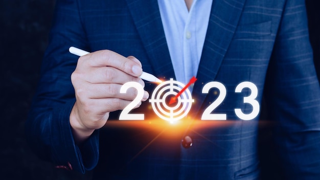 Objetivo comercial y meta 2023 icono mano apuntando sosteniendo pantalla virtual 2023 Comience el nuevo año 2023 con un plan de acción plan de acción estrategia año nuevo visión comercial
