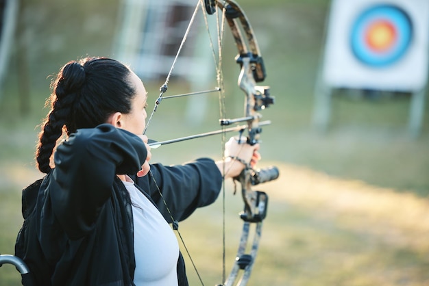 Foto objetivo de tiro con arco y entrenamiento con arco y flecha para el desafío de los atletas deportivos al aire libre o la competencia de campo de chicas el talento de los objetivos de tiro y el arquero competitivo se centran en el objetivo u objetivo de precisión