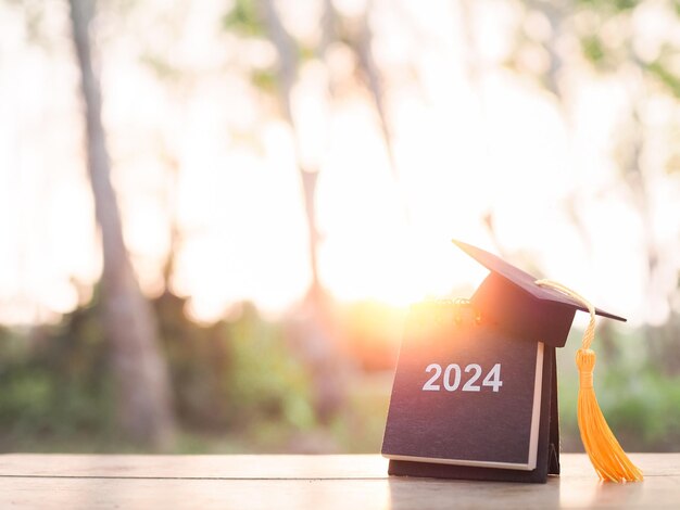 Foto objetivos de estudio 2024 calendario de escritorio con sombrero de graduación el concepto de resolución objetivo acción planificación y gestión del tiempo para el éxito graduado