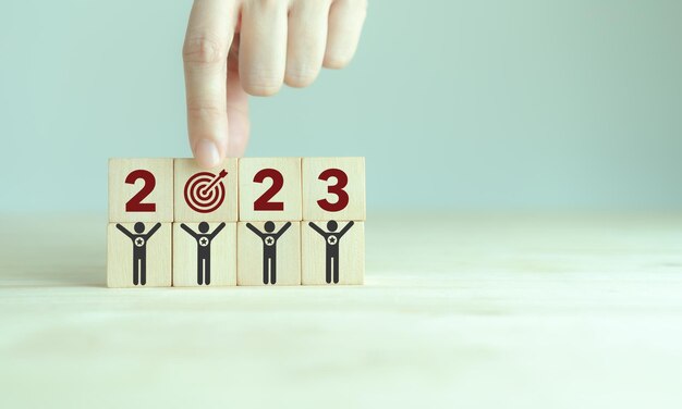Objetivos de negocio o vida de 2023 Construcción de equipos Cubos de madera con 2023 e icono de objetivo Comienzo del nuevo año Objetivos comunes de negocio para planificar nuevo proyecto plan anual logro de objetivos de negocio