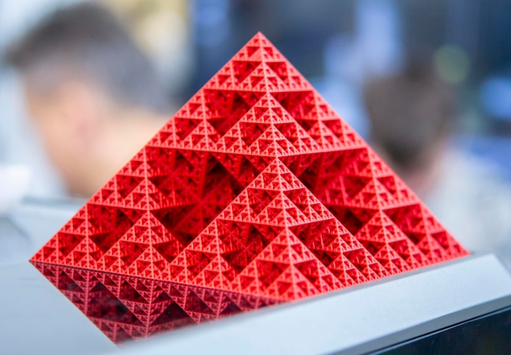Foto objeto de arte impreso en impresora 3d a partir de plástico rojo fundido modelo de primer plano de la pirámide creado en 3d