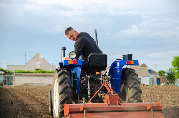 Oblast de Kherson Ucrania 29 de mayo de 2021 Un agricultor en un tractor limpia el campo después de la cosecha Preparación de la tierra para la futura siembra de nuevos cultivos Molienda del suelo Suelto del suelo antes de cortar las filas