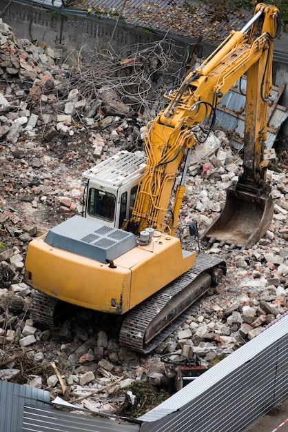 Obra de construcción cran y tractor destruyendo un edificio