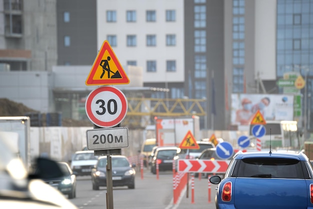 Obras rodoviárias avisando sinais de trânsito de obras na rua da cidade e carros em movimento lento