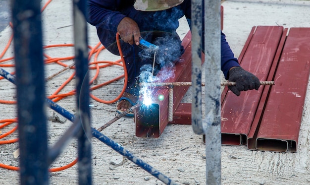 Obrero suelda el acero con chispas. sin usar ropa protectora Se puede encontrar en sitios de construcción en Asia.