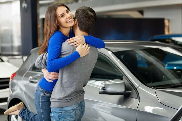Obrigado, querido! Jovem e linda mulher abraçando o namorado, obrigada pelo carro novo