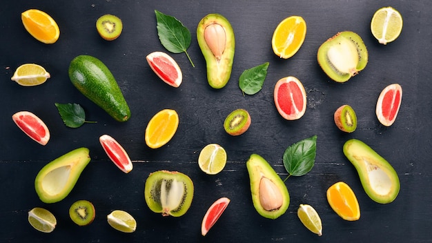 Obst auf einem hölzernen Hintergrund Avocado, Limette, Orange, Grapefruit und Kiwi Draufsicht Freier Platz für Ihren Text