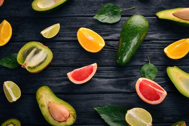 Obst auf einem hölzernen Hintergrund Avocado, Limette, Orange, Grapefruit und Kiwi Draufsicht Freier Platz für Ihren Text