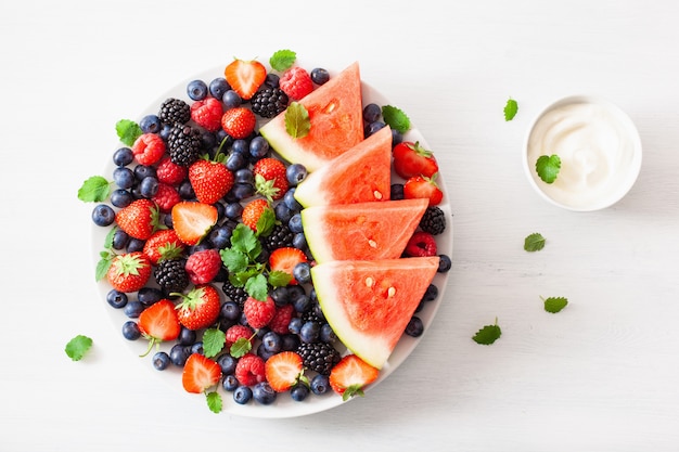 Obst- und Beerenplatte mit Joghurt über Weiß. Blaubeere, Erdbeere, Himbeere, Brombeere, Wassermelone