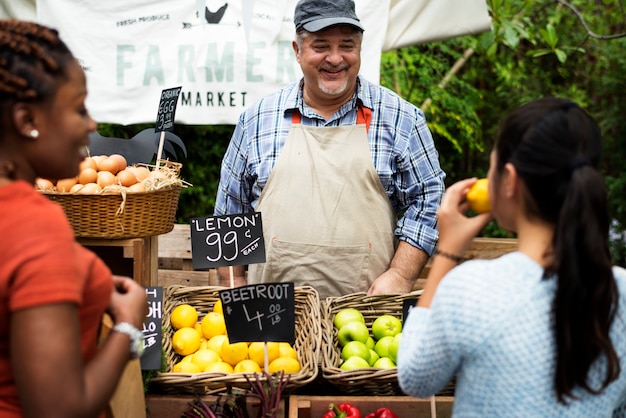 Obst-und Gemüsehändler, der organisches neues landwirtschaftliches Produkt am Landwirtmarkt verkauft