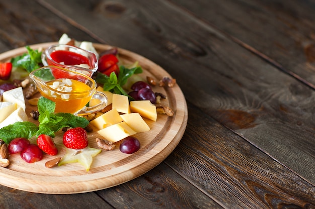 Obst- und Käseteller auf Holzschreibtisch