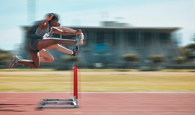 Foto obstáculos rápidos y equipo de mujeres en pista corriendo en maratón de carreras o competencia en el estadio entrenamiento físico y atletas femeninas saltando con velocidad y energía para entrenamiento al aire libre con movimiento borroso