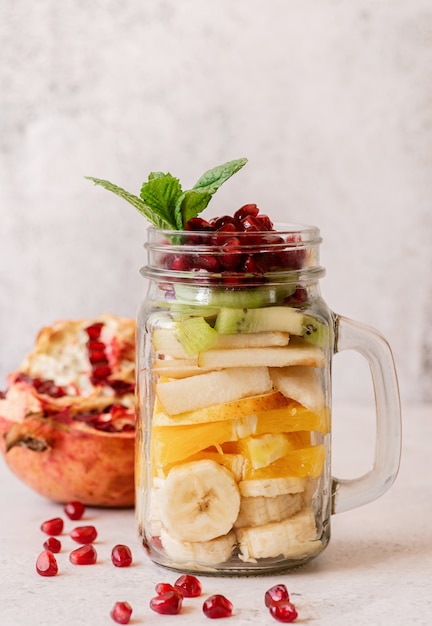 Obstsalat in einem Einmachglas auf hellem Hintergrund