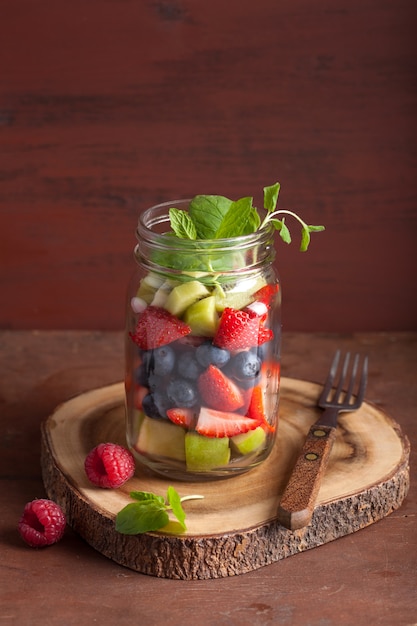 Obstsalat in Einmachglas Erdbeer Blaubeer Kiwi Apfel Minze