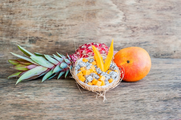 Obstsalat mit Drachenfrucht und Papaya in einer halben Kokosnuss