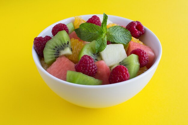 Obstsalat mit Kiwi, Minze und Himbeere in Schüssel