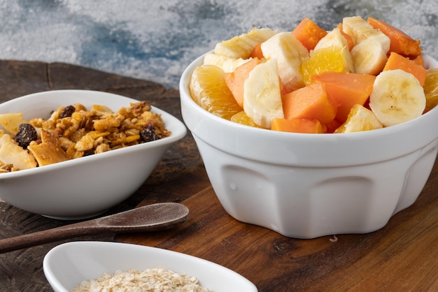 Obstsalat mit Müsli und Quinoa-Flocken in einer Schüssel. Gesundes Ernährungskonzept, selektiver Fokus