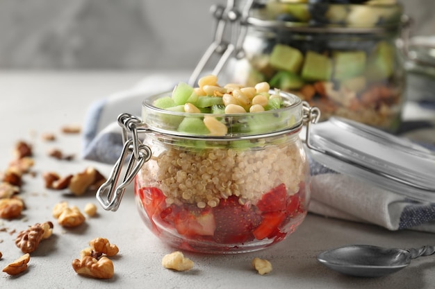 Obstsalat mit Quinoa serviert im Glas auf dem Küchentisch