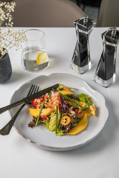 Obstsalat und schwarze Getränkeschale Gesundes Frühstück auf weißem Grund