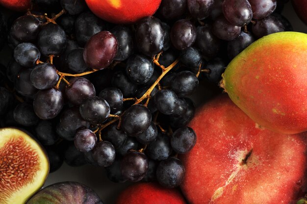 Obstteller mit Trauben, Pfirsichen, Birnen, Kirschen.