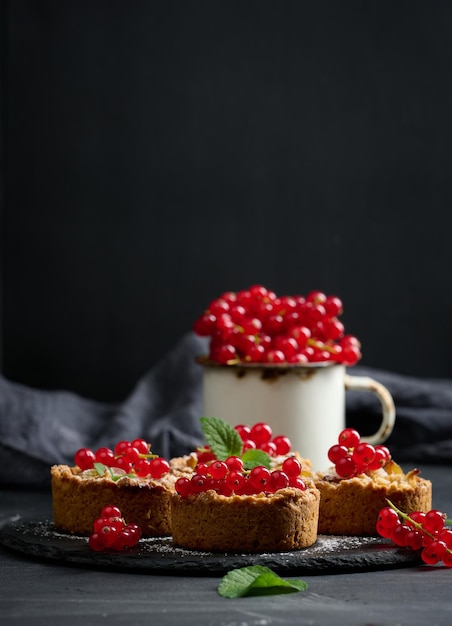 Obsttorte mit roter Johannisbeere auf schwarzem Tisch köstliches Dessert