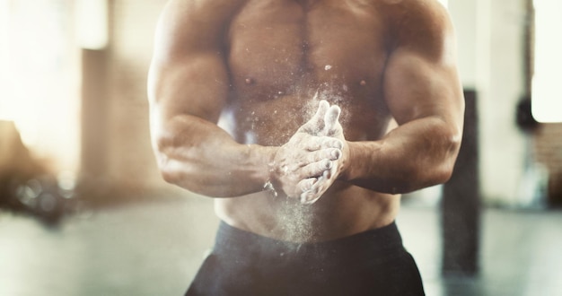 Obtenga un agarre Captura recortada de un joven irreconocible empolvándose las manos durante un entrenamiento en el gimnasio