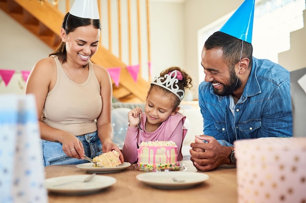 Obtienes la pieza más grande Foto de una niña celebrando un cumpleaños con sus padres en casa