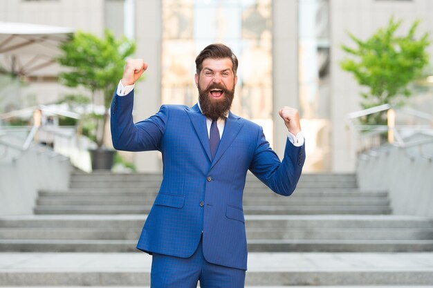 Obtuve la oferta ganadora Feliz hombre de negocios celebre con gesto ganador al aire libre Postor exitoso Ganó la victoria Éxito en los negocios Logros profesionales Moda formal