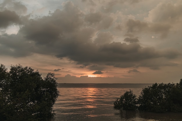 Oceano ao pôr do sol com nuvem de tempestade no céu