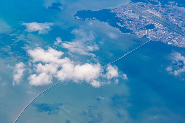 Foto océano azul profundo con nubes y una isla vista desde el cielo