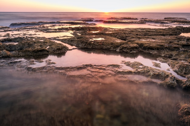 Oceano de longa exposição com pôr do sol