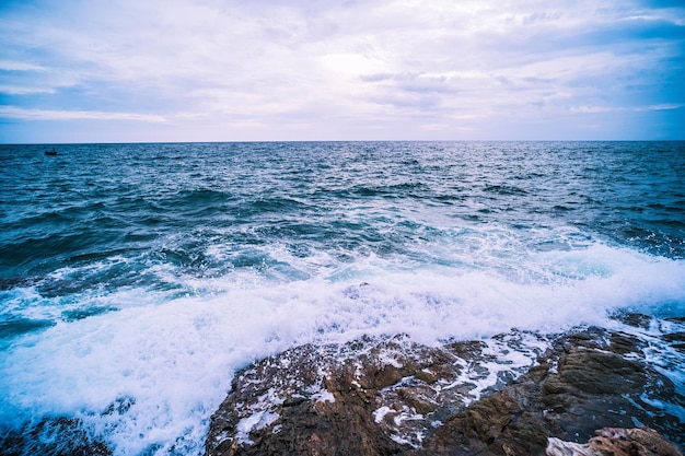 Oceano do mar com ondas suaves e paisagem rochosa com céu azul Natureza do tempo de férias Seascape
