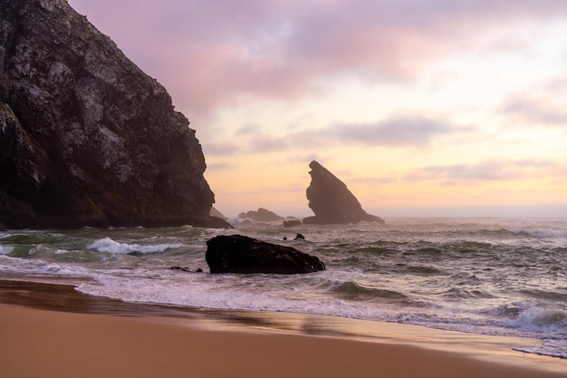 Oceano praia selvagem tempo tempestuoso Praia da Adraga com fundo de paisagem pitoresca Sintra Cascais Portugal