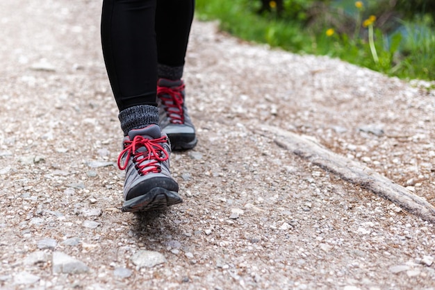 Ocio activo Cerrar botas de mujer de senderismo de altura media en una pista de montaña