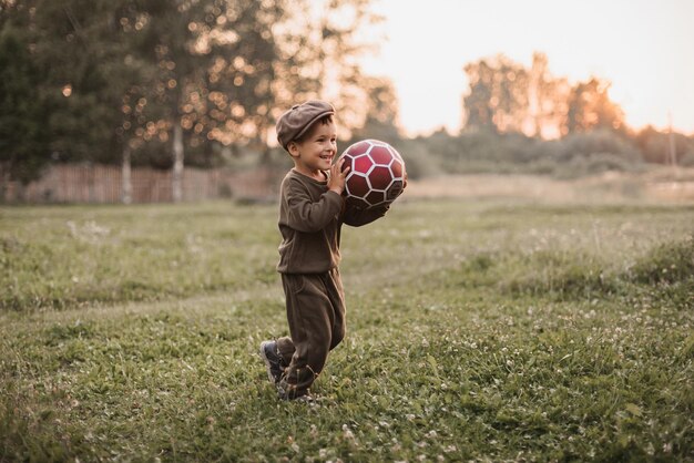 Ocio activo Un niño está jugando al fútbol al aire libre en el campo