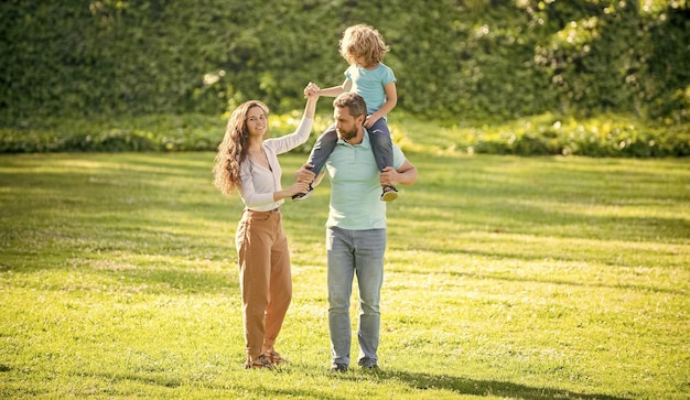 Ocio familiar Familia feliz con niño Madre e hijo cabalgando sobre el padre Disfrutando del tiempo libre Mamá y papá cargando al niño sobre los hombros Infancia y crianza de los hijos