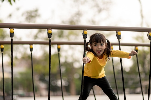Ocio infantil de verano y concepto de personas niña feliz en el parque infantil columpio