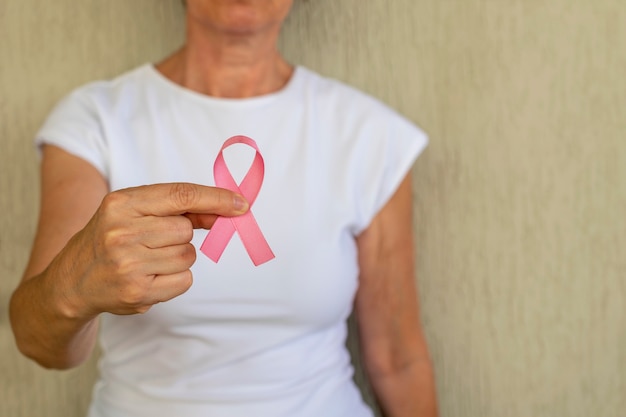 Octubre rosa salud de la mujer Mujer con lazo rosa en la mano Campaña de prevención del cáncer de mama