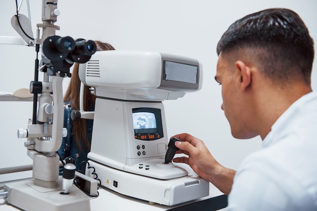 Oculist testa a visão do paciente usando uma máquina moderna especial.