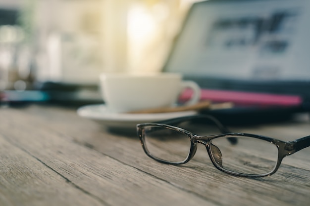 Foto Óculos com xícara de café na mesa