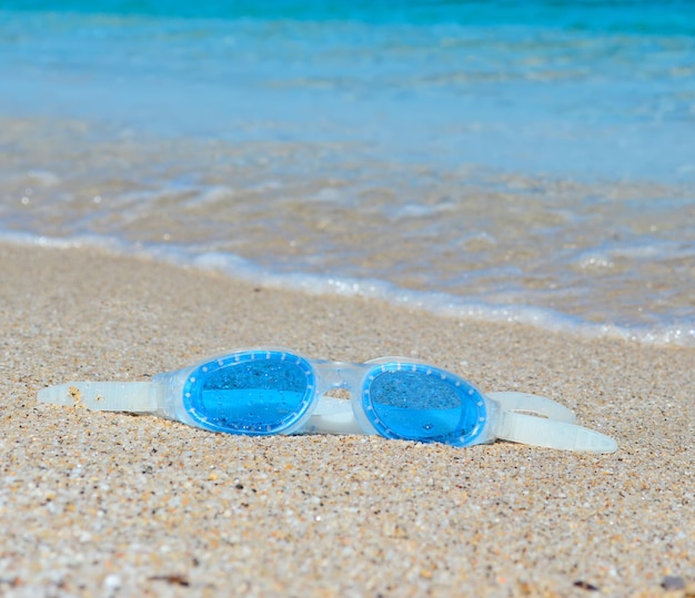 Óculos de mar azul em uma praia tropical