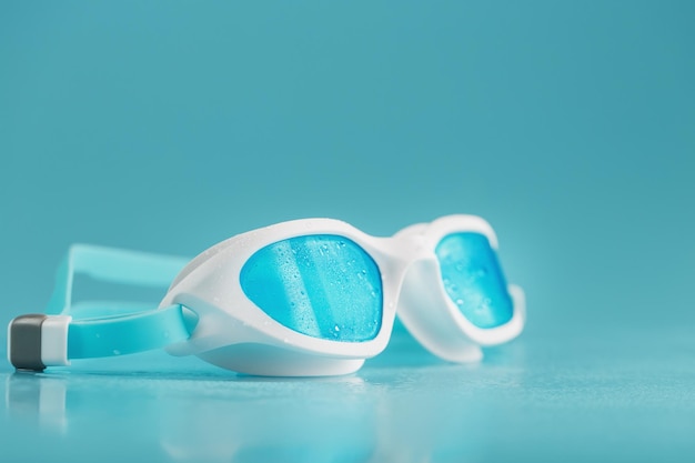 Foto Óculos de natação em uma moldura branca com um azul