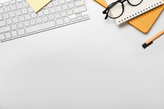 Foto Óculos de notebook de teclado sem fio plano leigo e caneta na mesa branca copie o espaço para o seu texto