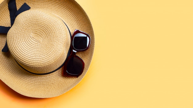 Óculos de sol com chapéu de verão em fundo laranja. aproveite o conceito de férias.