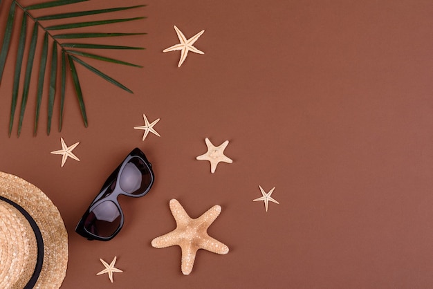 Óculos de sol com conchas e estrelas do mar em uma superfície colorida